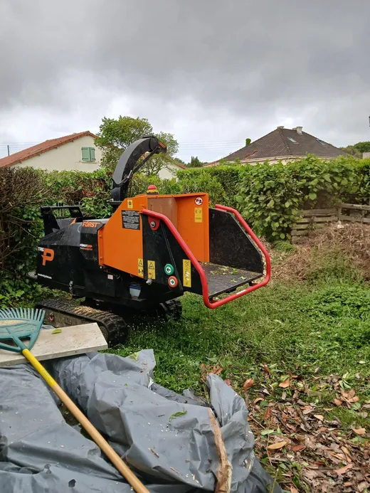 Broyeur de déchets verts orange en intervention en jardin